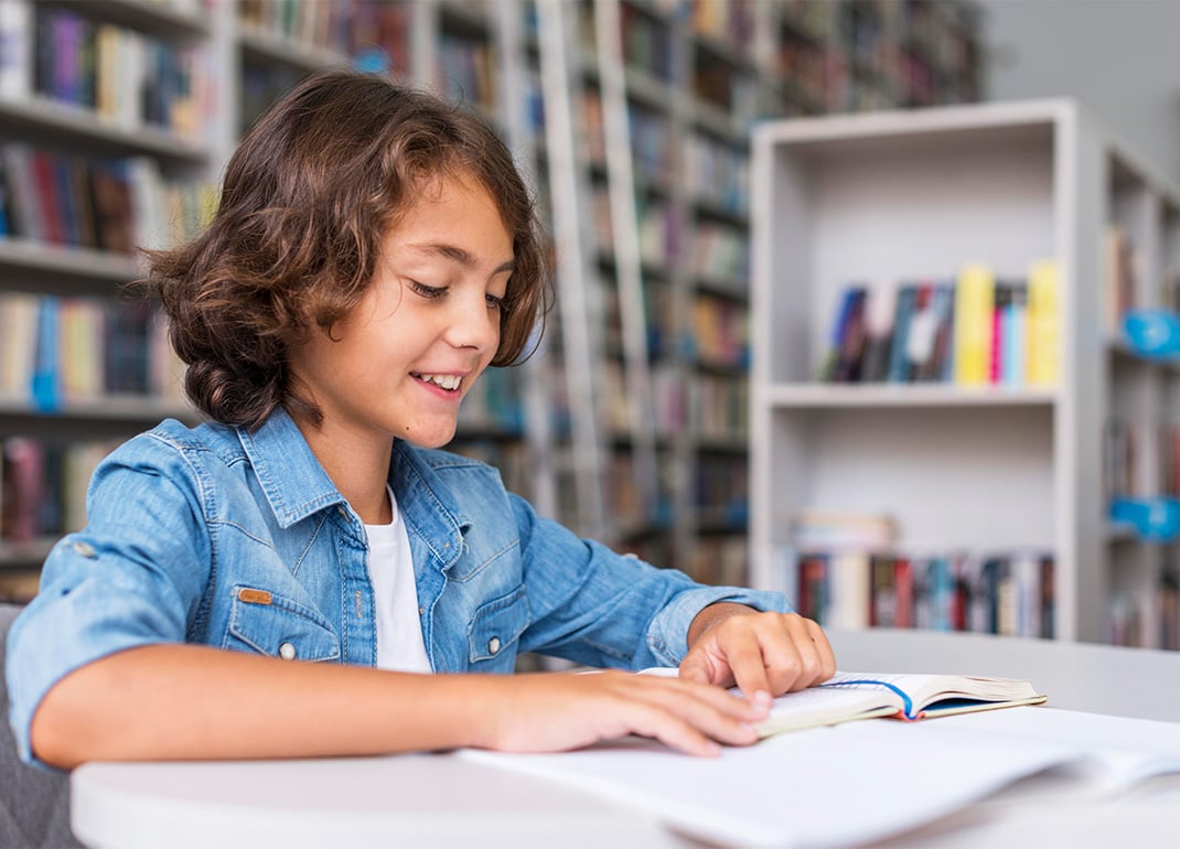 child-reading-book-in-library