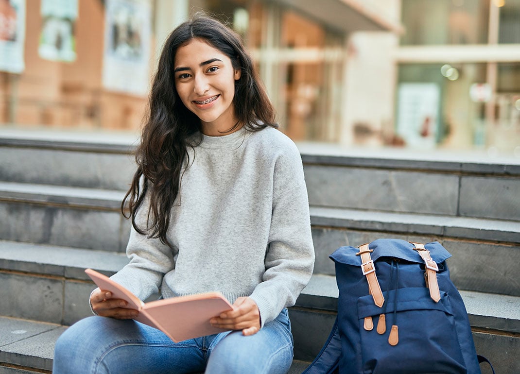 girl-sitting-on-steps-of-school girl-sitting-on-steps-of-school